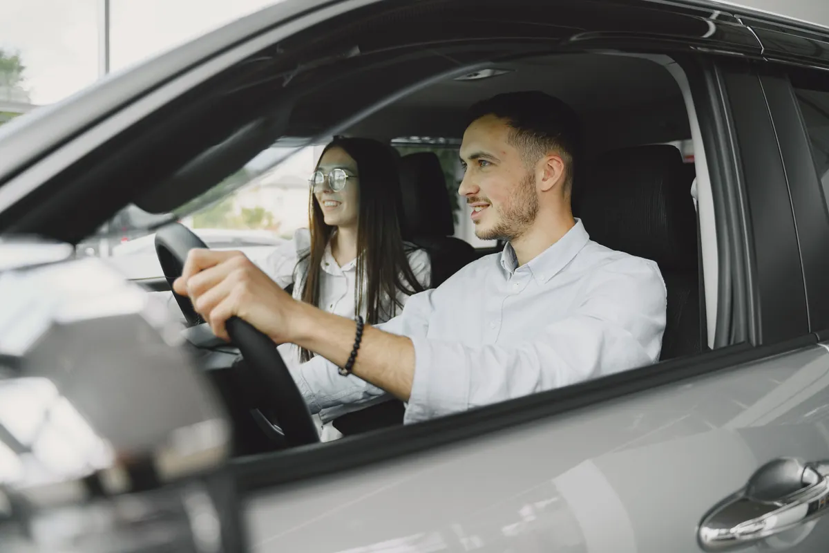 A driving instructor and a young learner driver practising together during a lesson